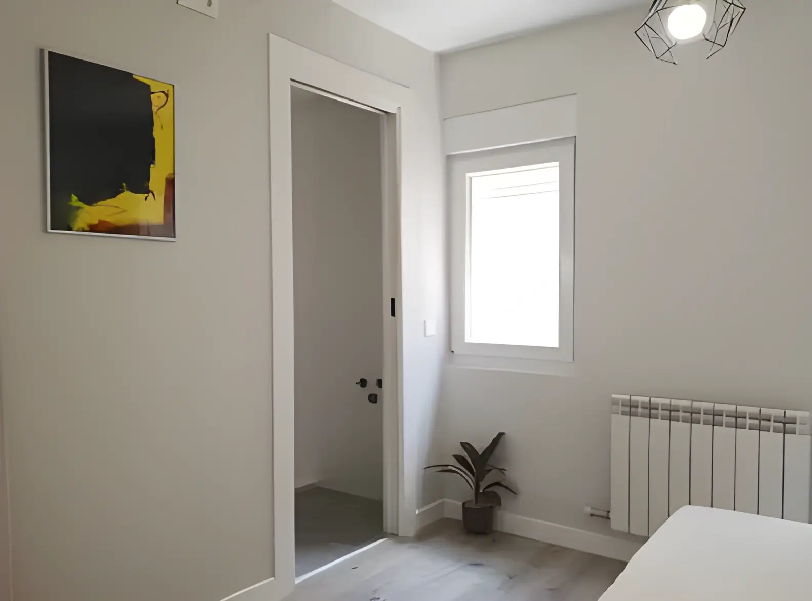 Habitación recién pintada en blanco por Los Pintores Móstoles para comunidad de vecinos