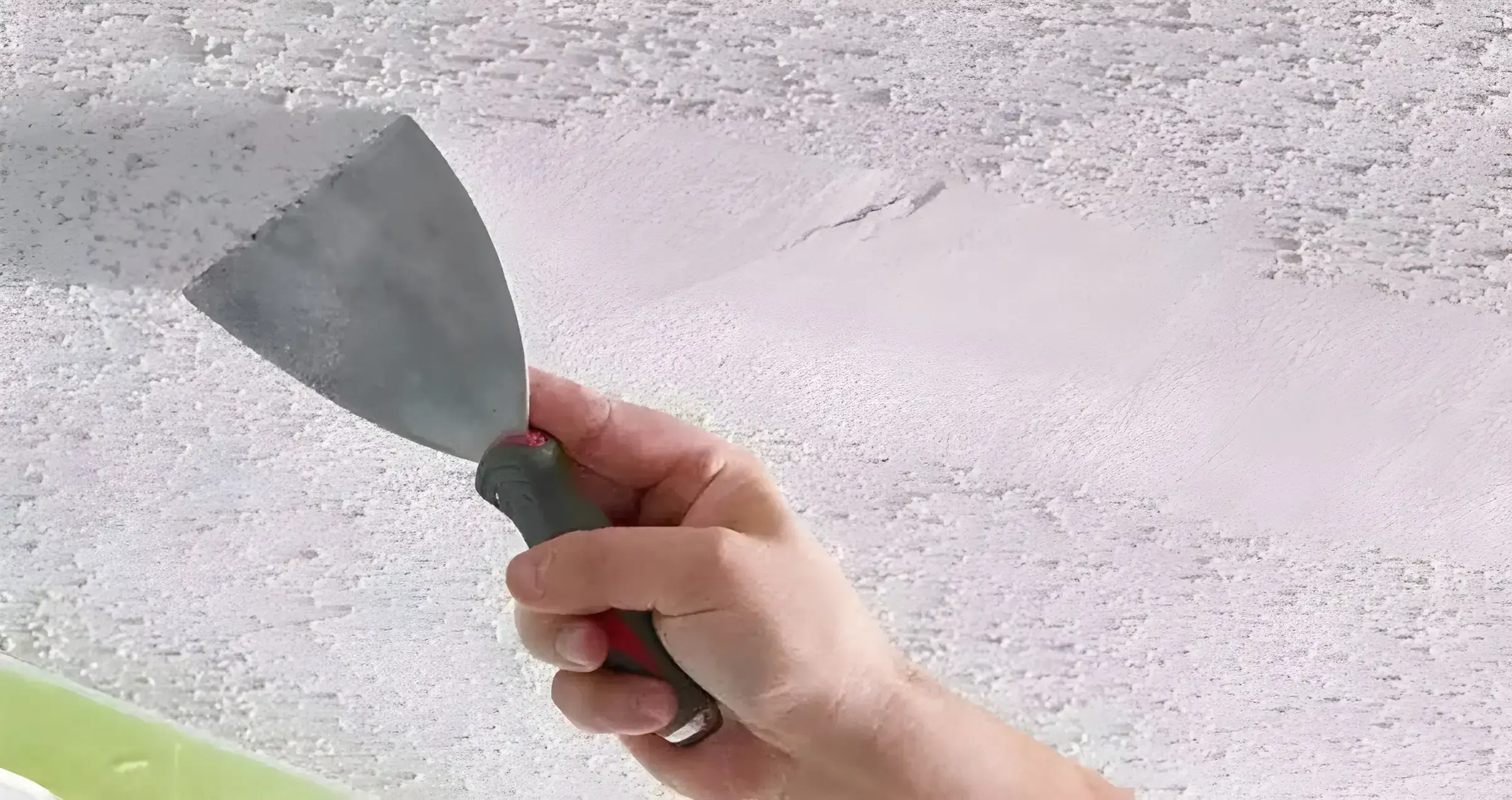 Los Pintores Móstoles eliminando el gotelé con espátula para dejar la pared lisa